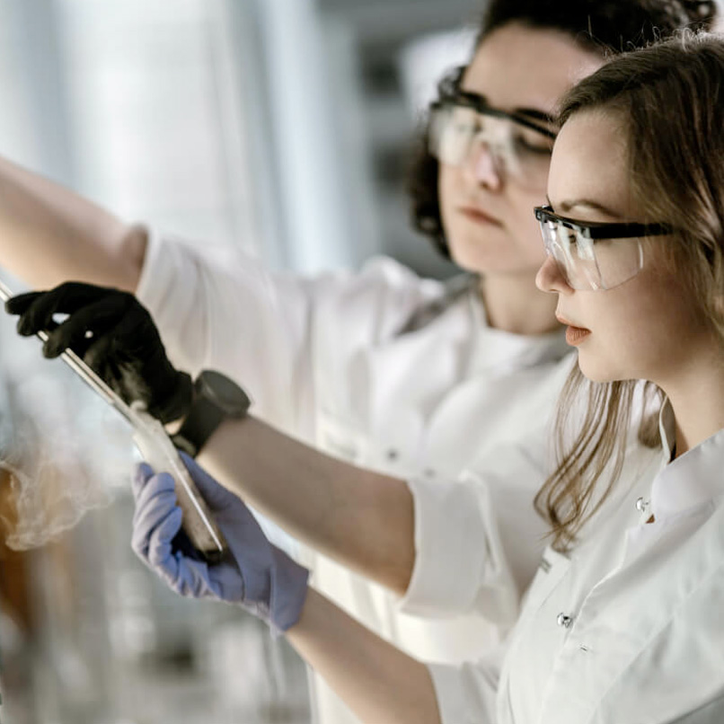 two scientists in lab wearing protective goggles
